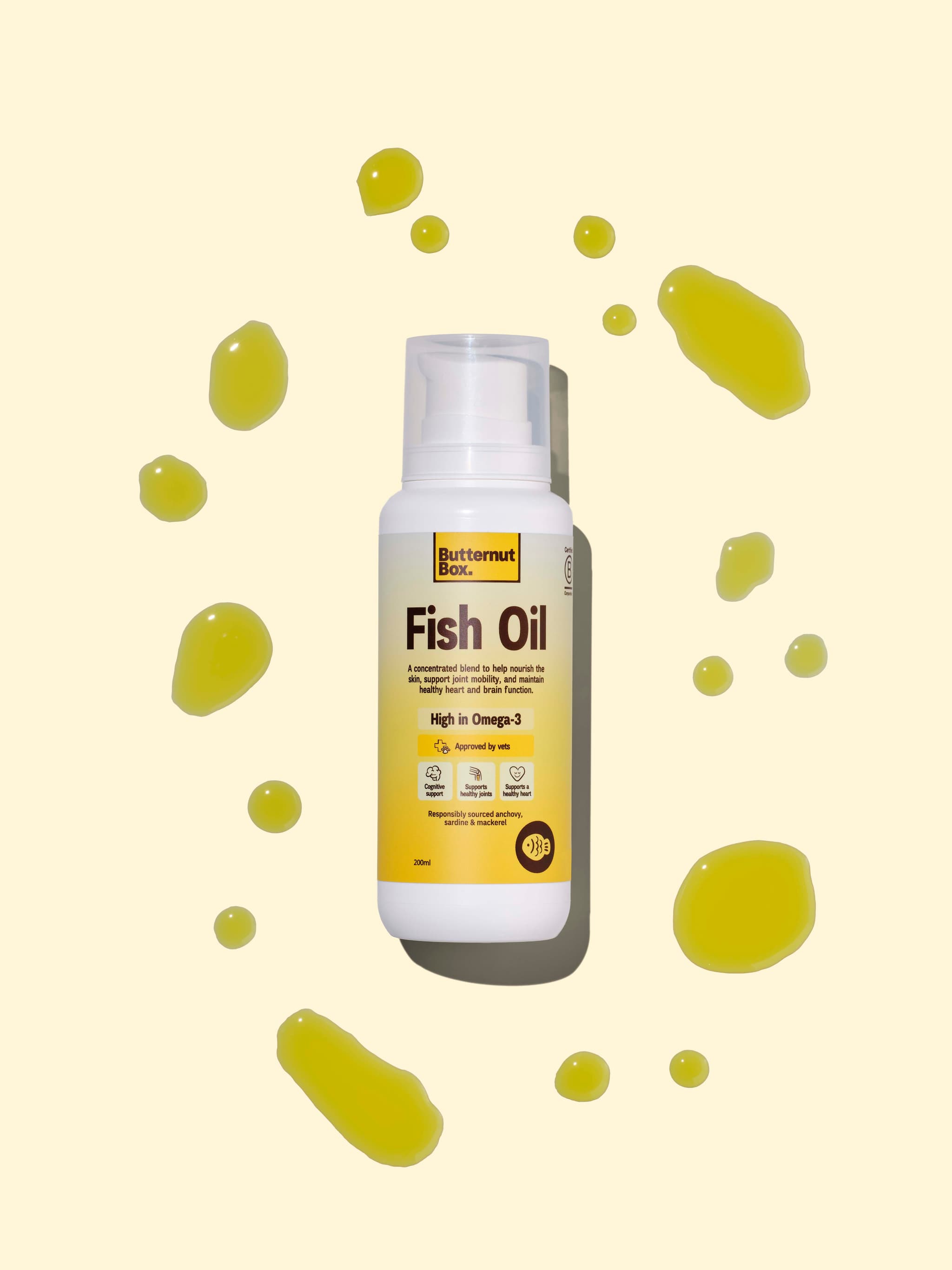 Butternut Box Fish Oil bottle surrounded by droplets on a cream background.