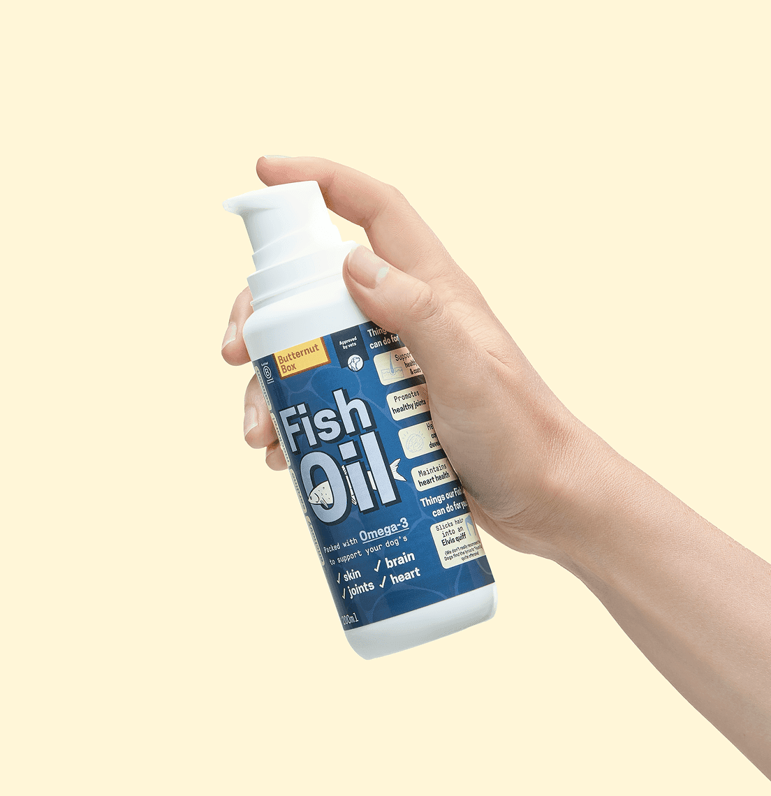 Hand holding a white pump bottle with a blue label reading "Fish Oil."