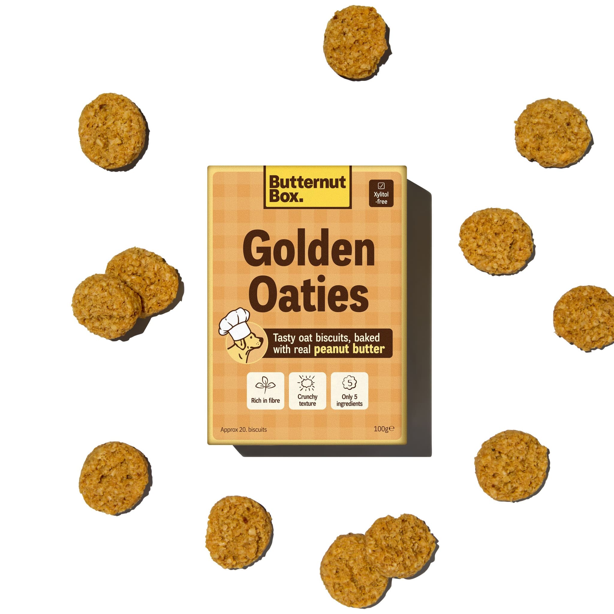Butternut Box Golden Oaties package surrounded by oat biscuits. The box highlights features like real peanut butter and xylitol-free.